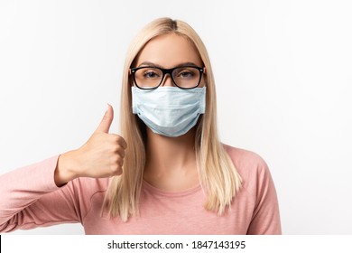 Woman In Medical Mask And Eyeglasses Showing Thumb Up Isolated On White