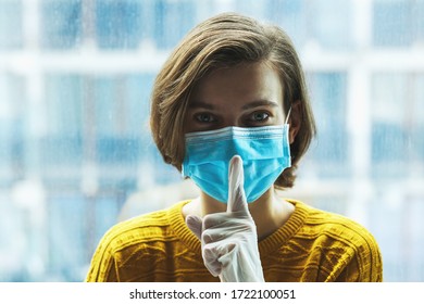 Woman In Medical Mask With Finger Near Mouth. Panic, Silence And Calm During Coronavirus Pandemic Concept.