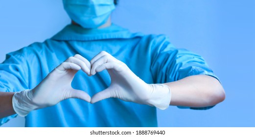 Woman With A Medical Mask And Hands In Latex Glove Shows The Symbol Of The Heart, Covid-19 Virus Treatment, Pandemic Response.