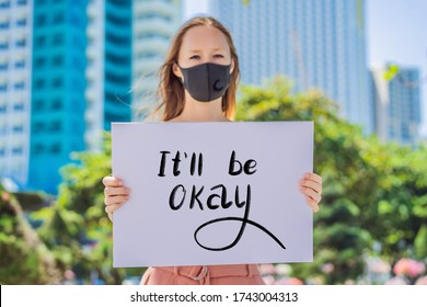 Woman In Medical Mask Prevents Coronavirus Disease Holds A Poster Everything Will Be Ok Hand Written Text - Lettering Isolated On White. Coronovirus COVID 19 Concept