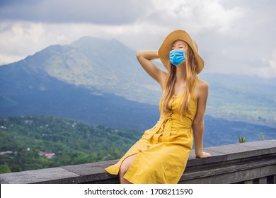 Woman In Medical Mask Traveler Looking At Batur Volcano. Indonesia Tourists Fear The 2019-ncov Virus. Medical Masked Tourists