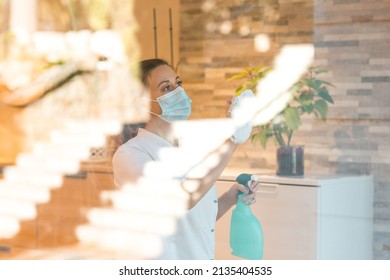 Woman In Medical Mask Washing Window With Detergent