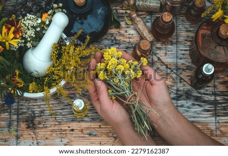 Woman with medicinal herbs and tinctures. Selective focus. Nature.