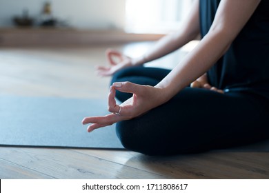 Woman meditating or doing yoga sitting on the mat cold blue tone