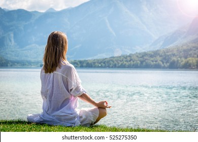 Woman Meditating At The Lake