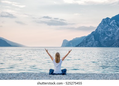 Woman Meditating At The Lake