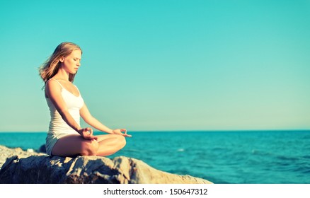 woman meditating in  lotus yoga on  coast of  sea on the beach - Powered by Shutterstock