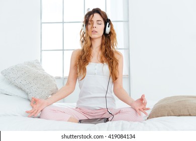 Woman Meditating On The Bed At Home