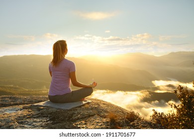 Woman meditating practicing yoga exercise in the mountain at sunset