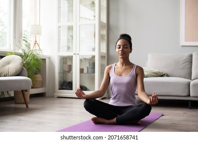 Woman Meditating And Practicing Yoga At Home. African American Girl Doing Relaxation Exercises. Training, Fitness, Mindfulness, Workout, Meditation, Self-care, Pilates, Healthy Lifestyle Concept