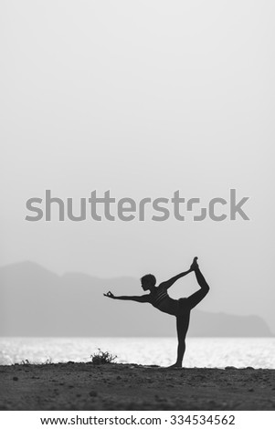 Woman meditating in yoga pose silhouette at the ocean, beach and mountains. Motivation and inspirational exercising. Healthy lifestyle outdoors in nature, fitness concept.