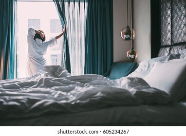 Woman meets rainy morning in luxus hotel room