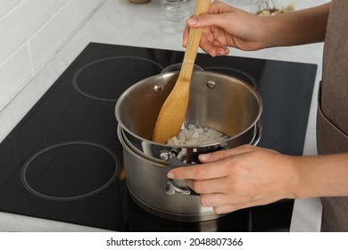 Woman Melting Wax On Stove In Kitchen, Closeup. Making Homemade Candles