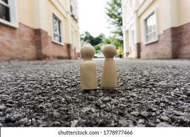 Woman and men wooden peg doll in the middle of the street road