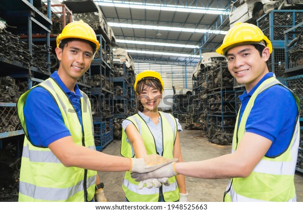 Woman and men work together, they look\
straight ahead. Asian engineer worker woman and man show teamwork\
and looking straight ahead in\
factory-warehouse