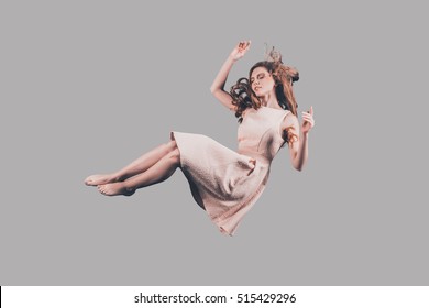 Woman in mid-air. Studio shot of attractive young woman hovering in air