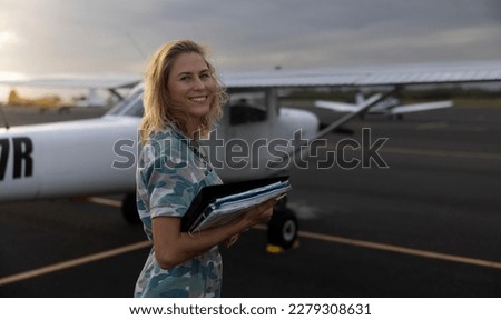 Woman in military uniform checking on a small aviation airplane. Flight pre-check inspection.