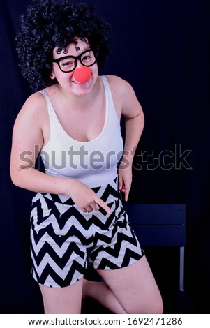 
woman with mime red nose, glasses and afro wig