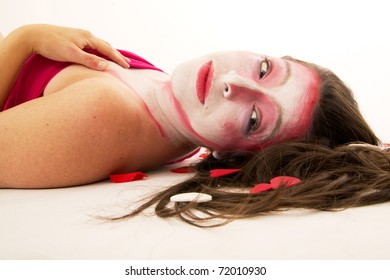 Woman mime with white and pink make up lying on back
