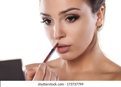 Woman With A Mirror That Is Applied A Lip Liner