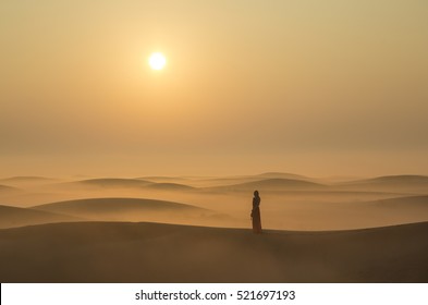 A Woman In A Mist In Desert Landscape At Sunraise Near Dubai, UAE