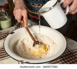 Woman Mixing Dough With Wooden Spoon At Home