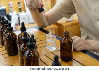 Woman Mixing Ingredients To Make Perfume 