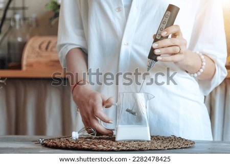 Woman mixing milk in glass by frother close up, making foamy milk with handheld mixer. Housewife female at home using mixer cooking food in kitchen. Cooking lifestyle concept. Copy ad text space