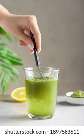 Woman Mixing Water With Green Superfood Powder. Alternative Herbal Medicine Concept. Vertical Image, Selective Focus