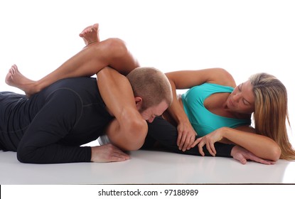 Woman in MMA attire applying a triangle choke against an opponent