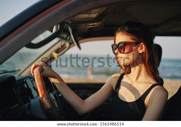 woman model looks\
at the sea sitting in a\
car