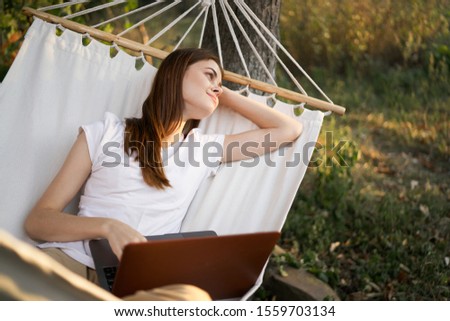 woman model resting in a white hammock on the street