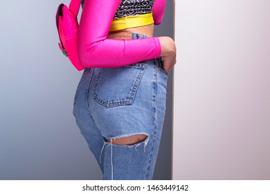 Woman Model Wearing Ripped Jeans And Colorful Pink Fanny Pack, Cool Fashion Festival Look