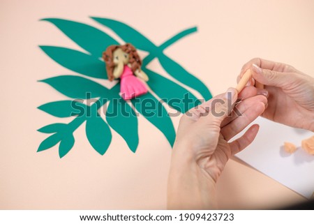 Woman modeling doll by colorful plasticine. People hobby concept