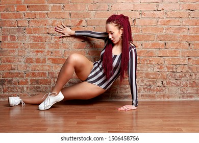 Woman Modern Dancer Dancing On A Brick Wall Background. Vogue Dance, Dance Hall. Afro Braids Of Bright Color