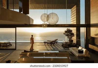 Woman in modern house overlooking ocean - Shutterstock ID 2328313927