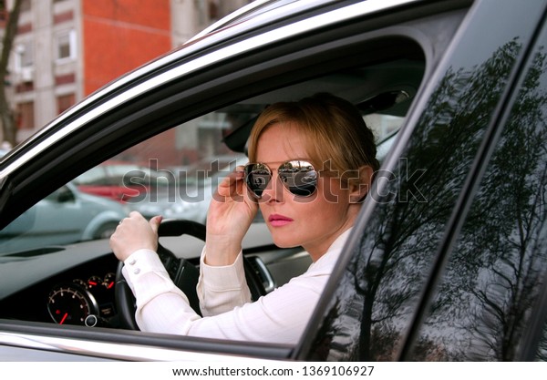 Woman with modern\
sun glasses driving a car