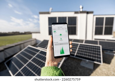 Woman monitors energy production from the solar power plant with mobile phone. Close-up view on phone screen with running program. Concept of remote control of solar energy production - Powered by Shutterstock