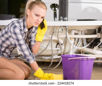 Woman Mopping Up. She Is Calling To Plumbing.