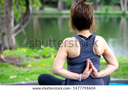 Woman more than 50 year old practicing yoga outdoor location near the lake in the park area. enjoy nice day in nature and positive energy