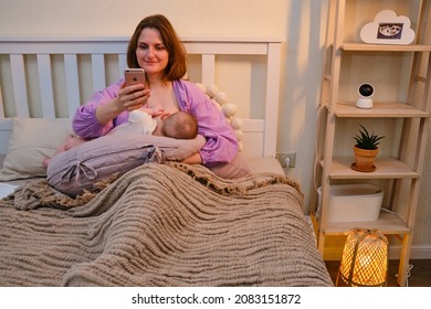 Woman Mother Breastfeeding Infant Baby With IPhone Apple - Moscow, Russia, November 15, 2021