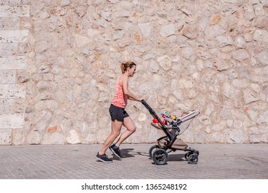 Woman, Mother Doing Fitness Pushing The Baby Stroller.