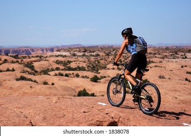 Woman Mountain Biking In Moab