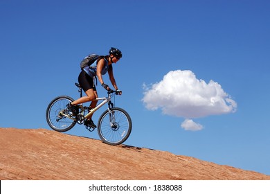 Woman Mountain Biking In Moab