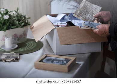 Woman in mourning packing remembrances after dead husband - Shutterstock ID 307235657