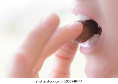 Woman Mouth Bites In Chocolate Egg