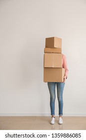 Woman With Moving Boxes Near Light Wall In Room