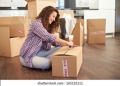 Woman Moving Into New Home And Unpacking Boxes