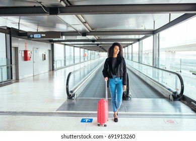 Woman In The Moving Walkway At The Airport With A Pink Suitcase.