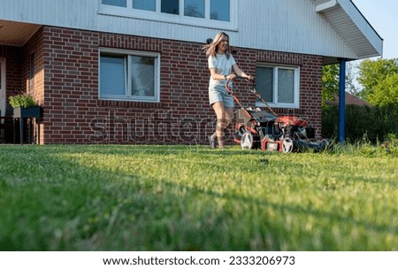 woman mowing lawn in garden